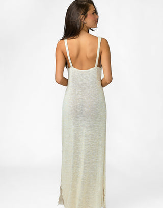 Woman wearing a long, light-colored dress with thin straps on a white background