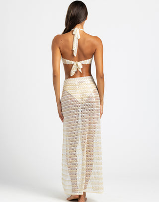 The model is wearing a white bandeau-style top with a halter tie and a keyhole cutout at the center, combining a chic and beach-ready design.