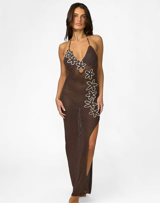 Woman wearing a brown mesh dress with floral designs on a white background