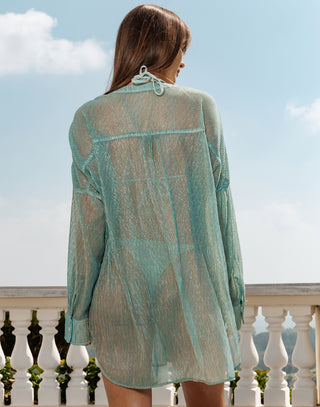 Woman wearing a sheer green dress with a blurred background