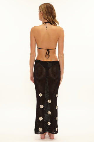 Woman wearing a black floral dress on a white background