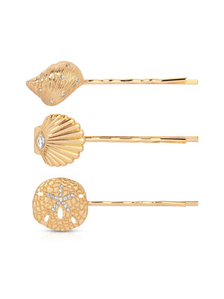 Set of three gold hair pins with shell and sand dollar designs on a white background