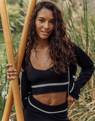 Woman holding a wooden surfboard in a natural setting