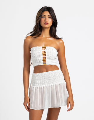 The image shows a white strapless top featuring a ruched design with gold bead accents connecting the fabric at the front for a stylish and modern look.