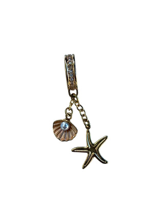 Gold charm with starfish and shell on a white background